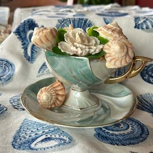 Seashell flower arrangement in a vintage tea cup